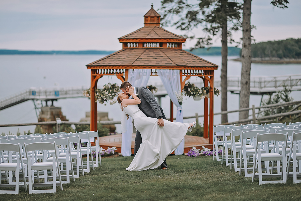 Photo of groom dipping the bride in front of the wedding gazebo at the Atlantic Oceanside Hotel
