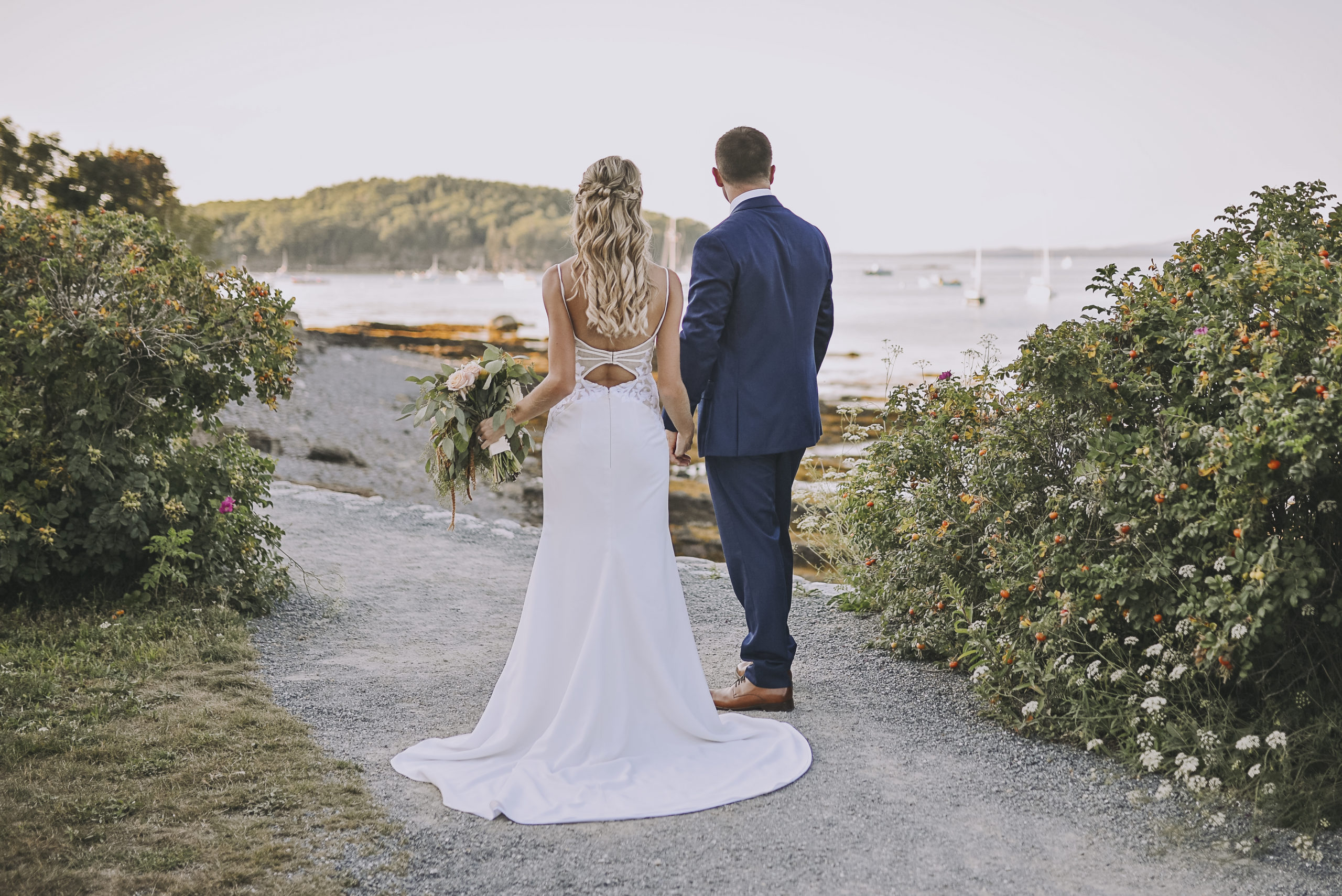 Photo of a bride and groom walking on the Shore Path in front of the Bar Harbor Inn