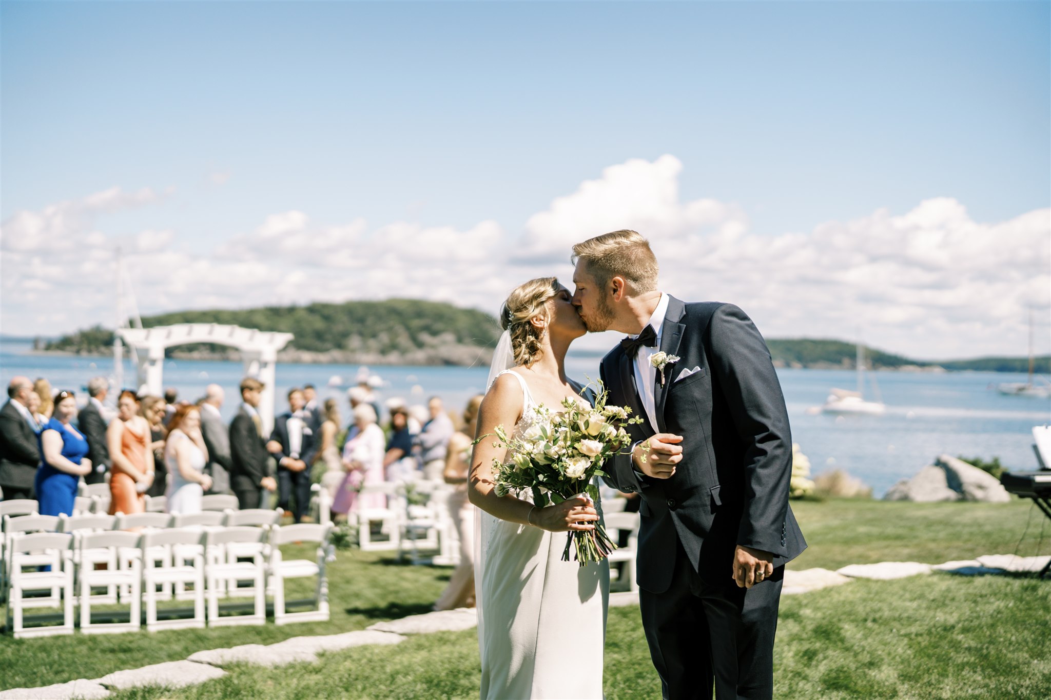 Photo of Bride and Groom kissing on the wedding lawn at at the Bar Harbor Inn